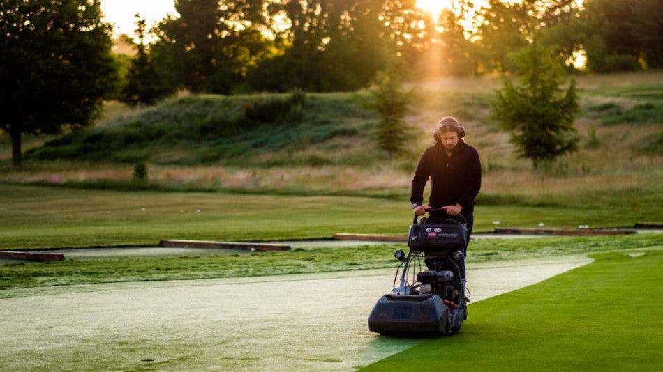 Entretien d'un green de golf au lever du soleil